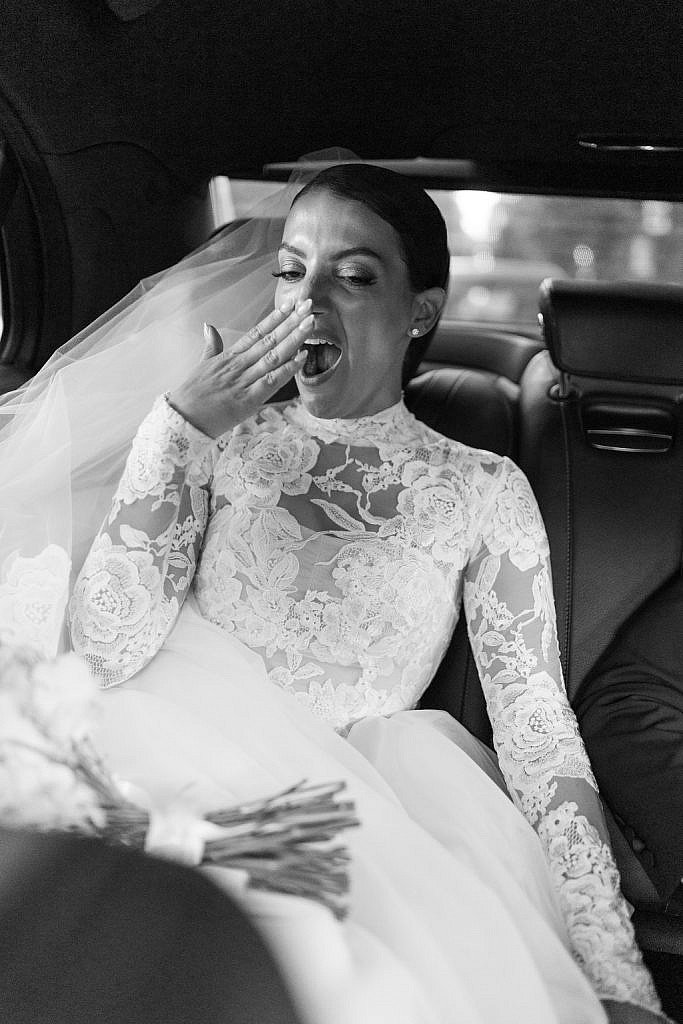 bride finally relaxing in her wedding car after the elegant catholic ceremony in florence