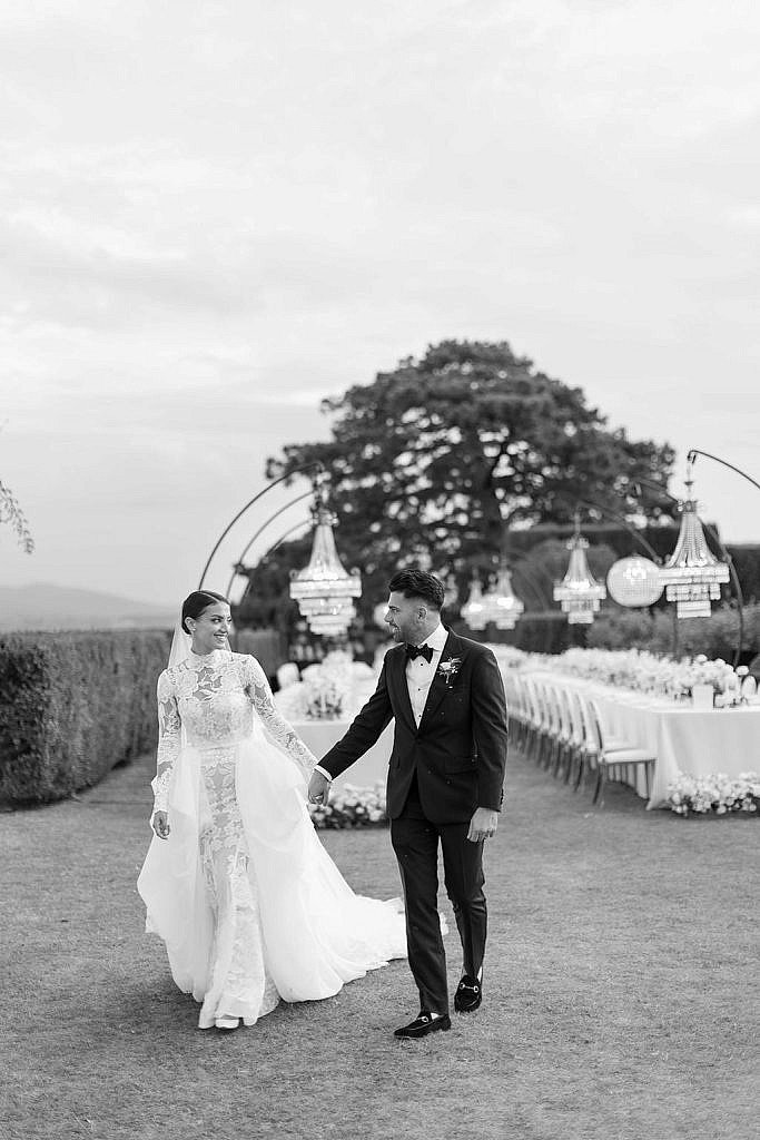 newlyweds walking through their luxury wedding tables in villa gamberaia florence