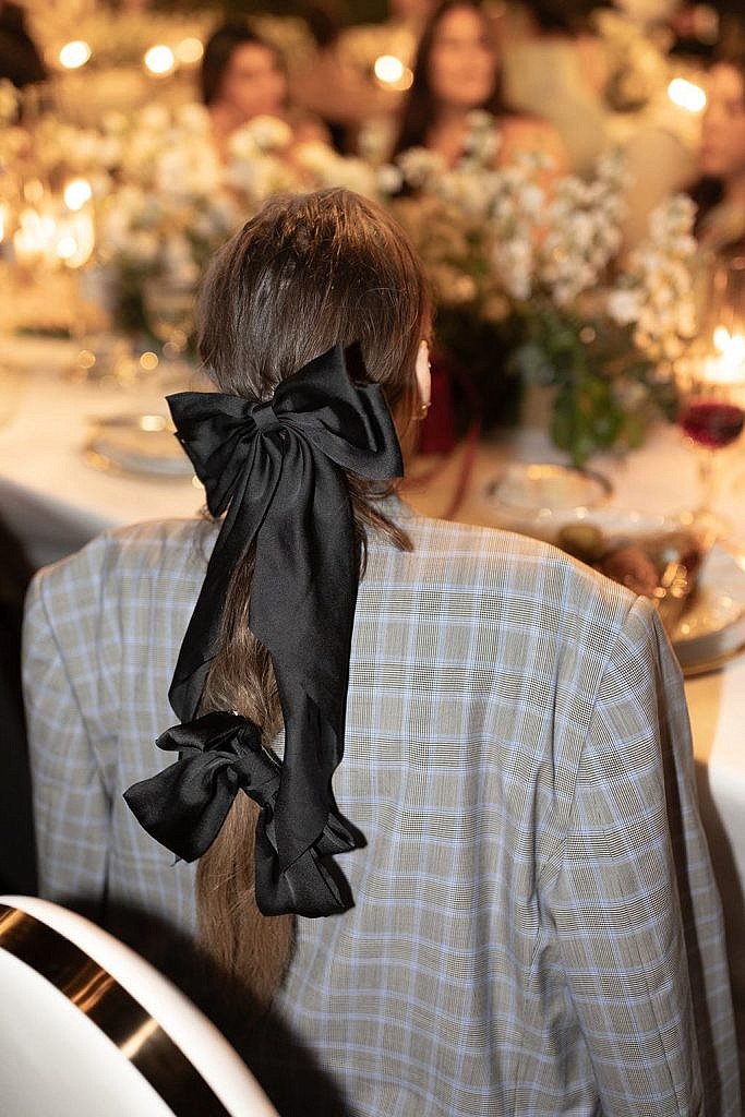 wedding guest wearing two giant bows for hair clips during the wedding dinner in florence