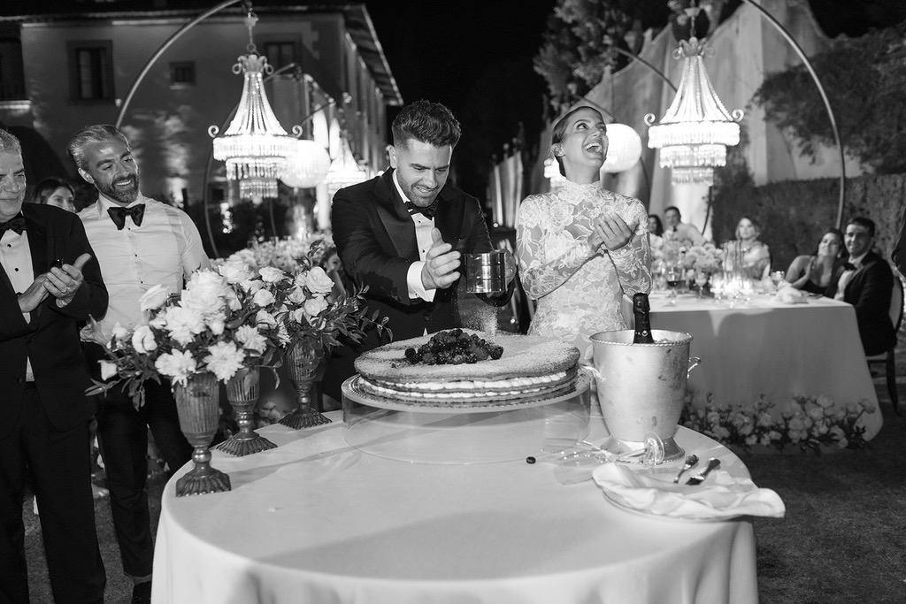 newlyweds enjoying their wedding cake during their luxury wedding at villa gamberaia in florence