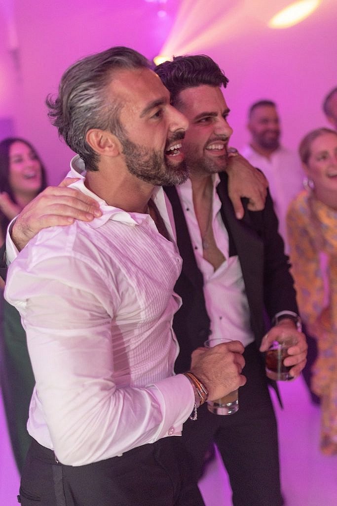 groom and his best man enjoing the dancing wedding party at villa gamberaia in florence